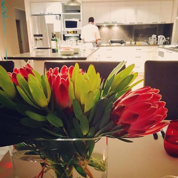 chef Eric at home cooking in the kitchen for private dining party with flowers in the foreground